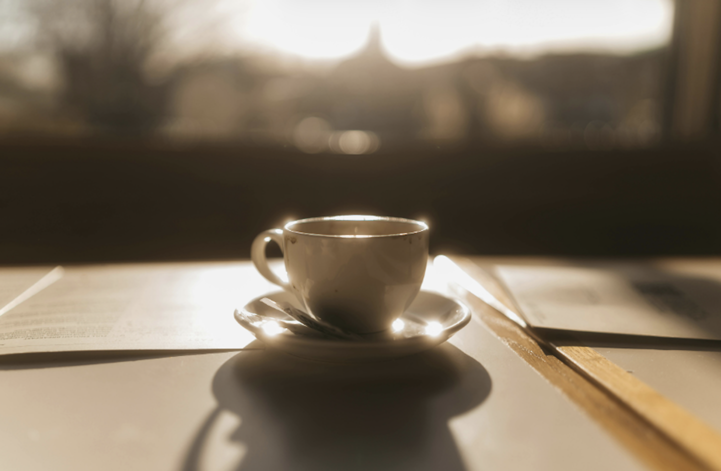 夕陽暖光下的咖啡杯與桌面靜物寫實照片